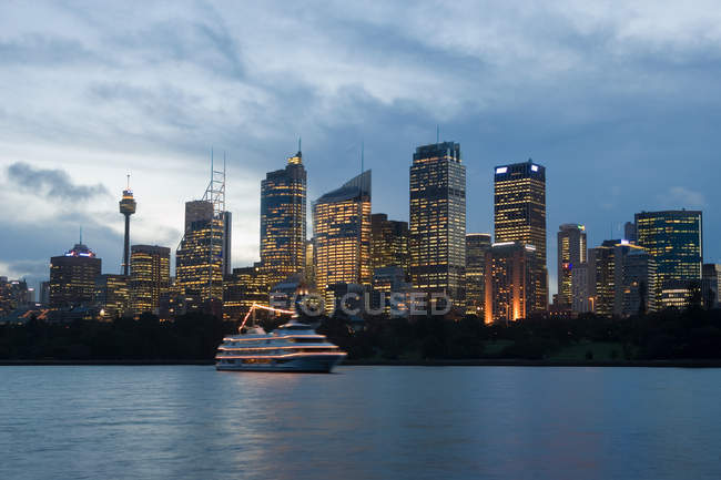 Boat and sydneys skyline at dusk — Stock Photo