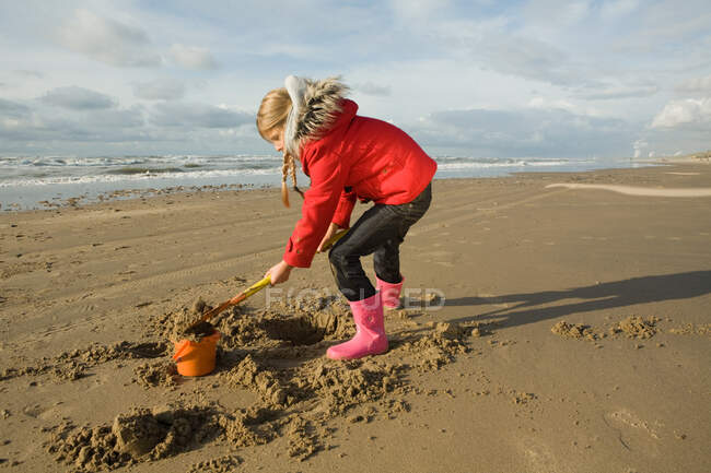 Девушка играет с песком — стоковое фото