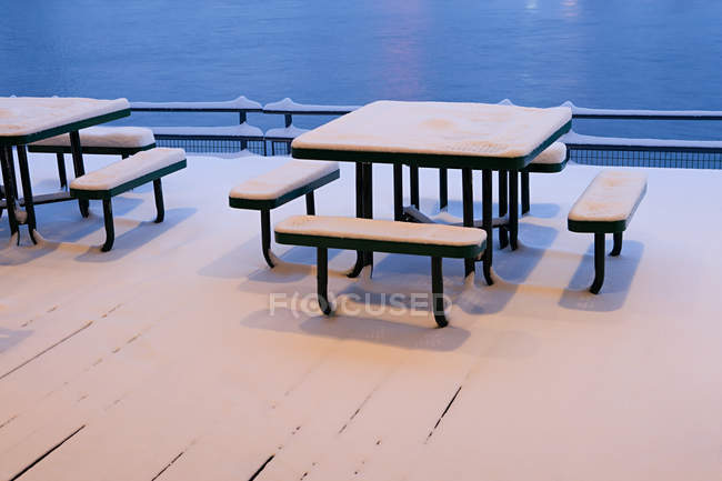 Mesas y bancos cubiertos de nieve - foto de stock