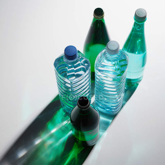 Пластикові та скляні пляшки води — стокове фото