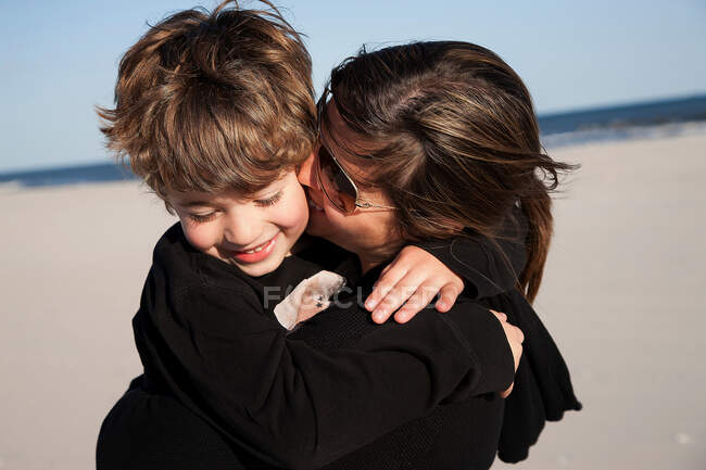 Madre baciare figlio su guancia — Foto stock