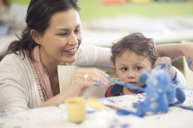 Madre y niño pequeño pintando en clase de arte - foto de stock