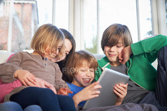 Hermanos usando tableta digital juntos - foto de stock