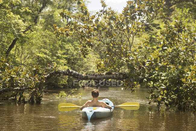 Мальчик-подросток на байдарке, Экономфина Крик, Янгстаун, Флорида, США — стоковое фото