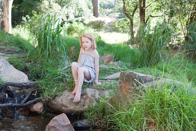 Девушка на скалах у реки — стоковое фото
