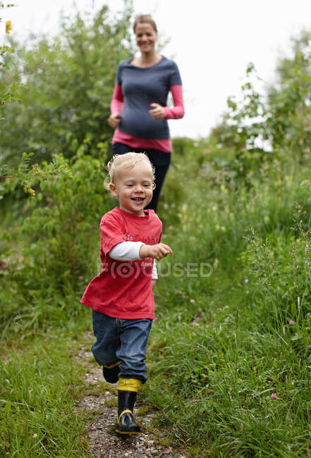 Mother and son running on dirt path — Stock Photo