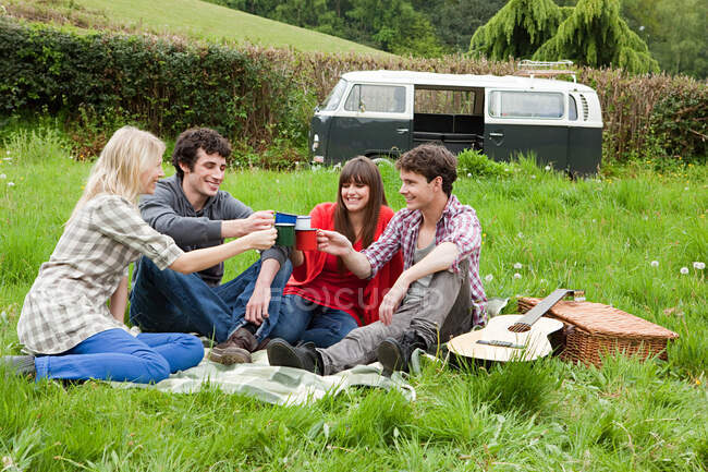 Friends toasting with mugs outdoors — Stock Photo