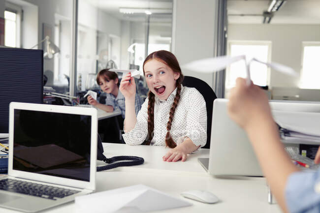 Children holding paper airplanes in office — Stock Photo