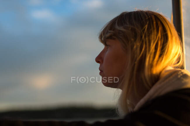 Woman looking out from boat at sunset on coast of Maine, USA — Stock Photo
