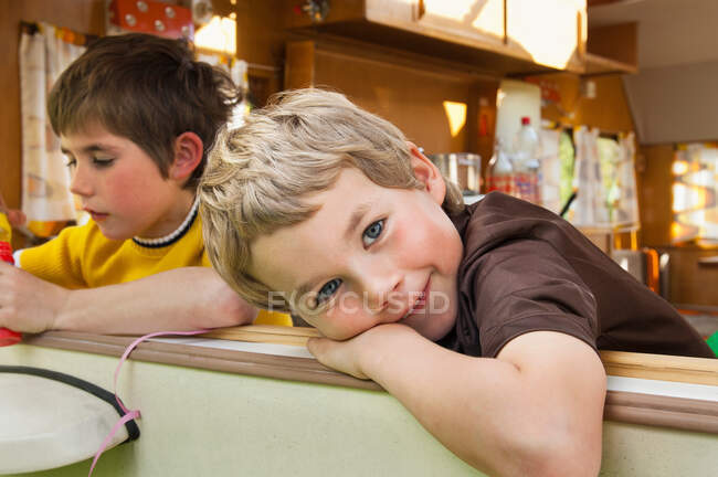 Two boys leaning out of caravan window, portrait — Stock Photo