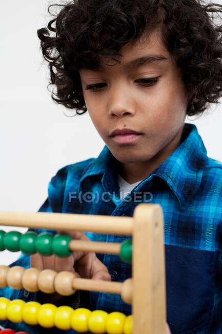 Мальчик, играющий с Абакусом — стоковое фото