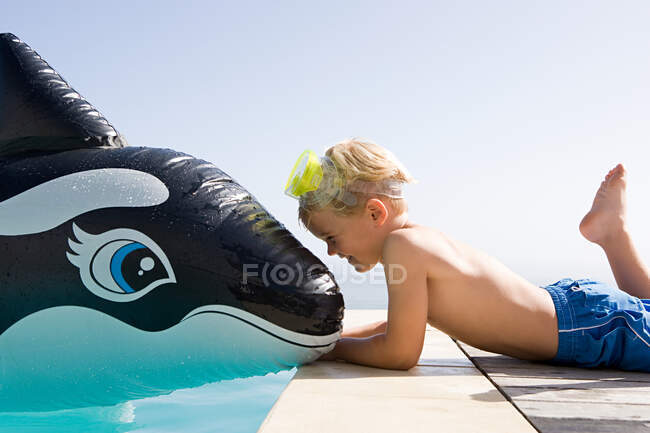 Мальчик с надувным китом — стоковое фото