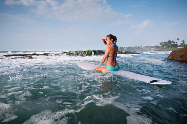 Surfer surveying waves on beach — Stock Photo