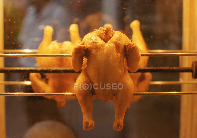 Close up of Spit roasted chicken roasting — Stock Photo