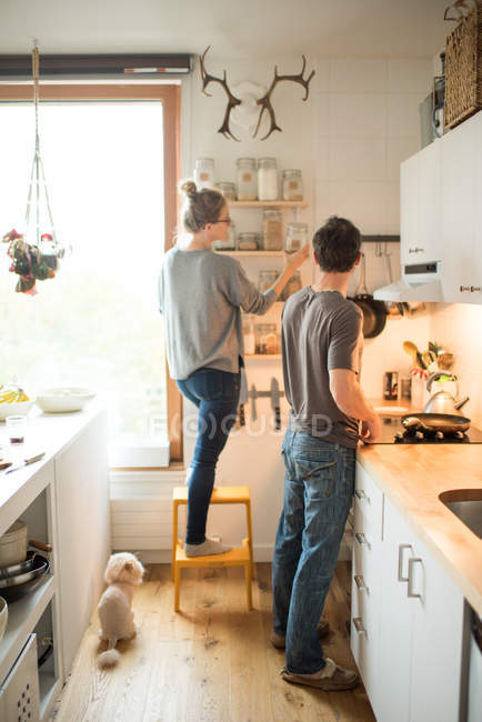Жінка і хлопець вибирають банку на кухні — стокове фото