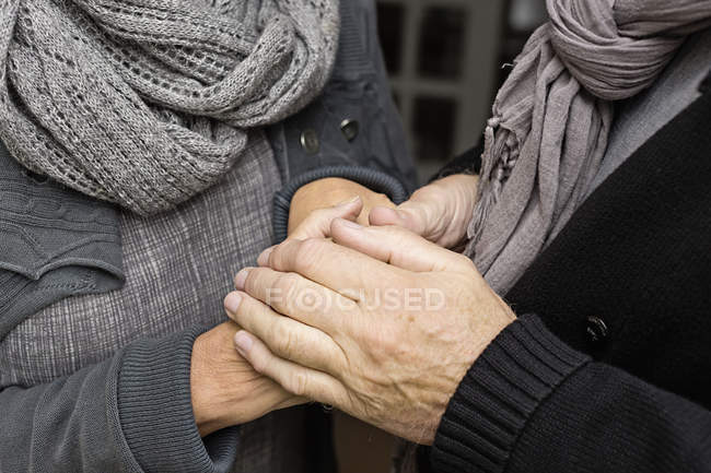 Старша пара тримає руки, крупним планом — стокове фото