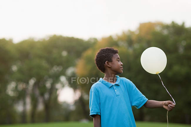 Boy at birthday party holding balloon — Stock Photo