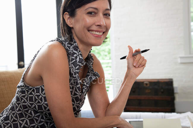 Femme mûre au bureau souriant, portrait — Photo de stock