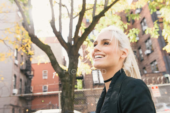 Portrait of woman on street looking away and smiling — Stock Photo