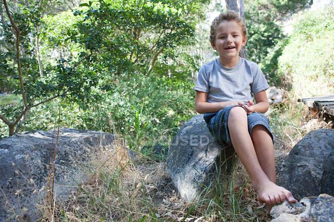 Rapaz sentado na pedra — Fotografia de Stock