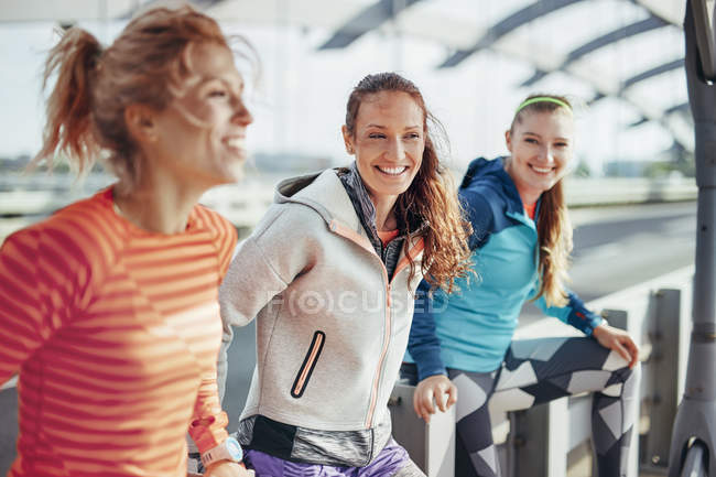 Retrato de tres corredoras en la pasarela de la ciudad - foto de stock