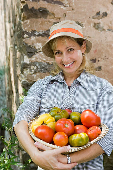 Femme avec bol de tomates — Photo de stock