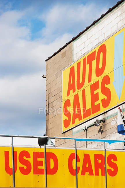 Auto vente et voitures d'occasion signes sur ciel nuageux bleu — Photo de stock