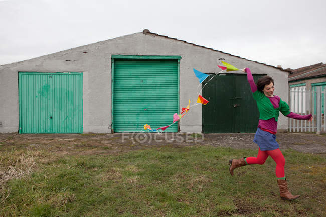 Young woman running with bunting — Stock Photo
