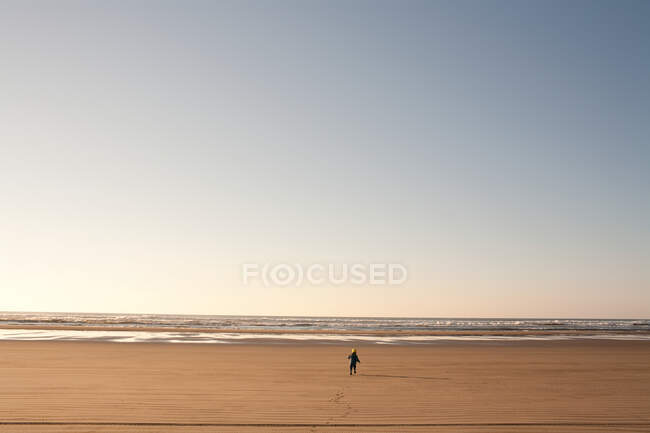 Jeune garçon courir sur la plage de sable fin — Photo de stock