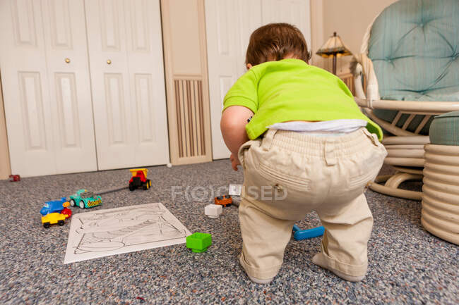 Jeune homme tout-petit jouant avec des jouets — Photo de stock