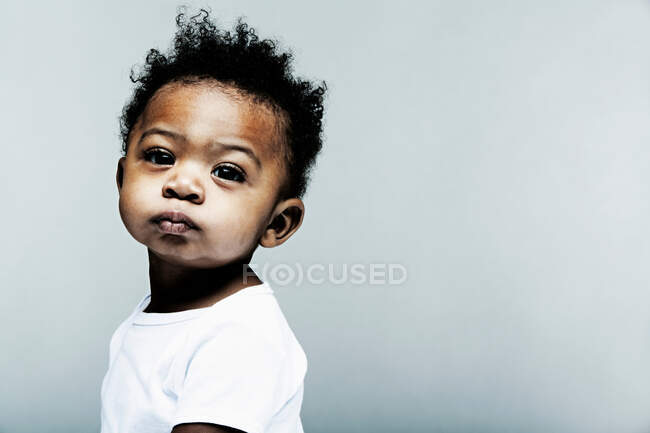 Portrait de bébé garçon portant blanc regardant la caméra — Photo de stock