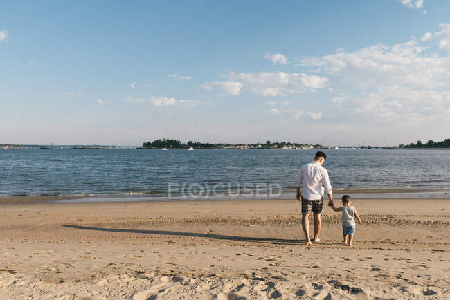Jeune couple marchant sur la plage — Photo de stock