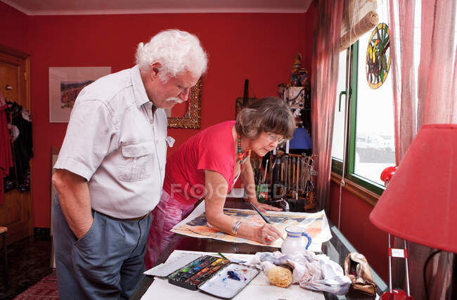 Uomo ammirando la pittura della moglie — Foto stock