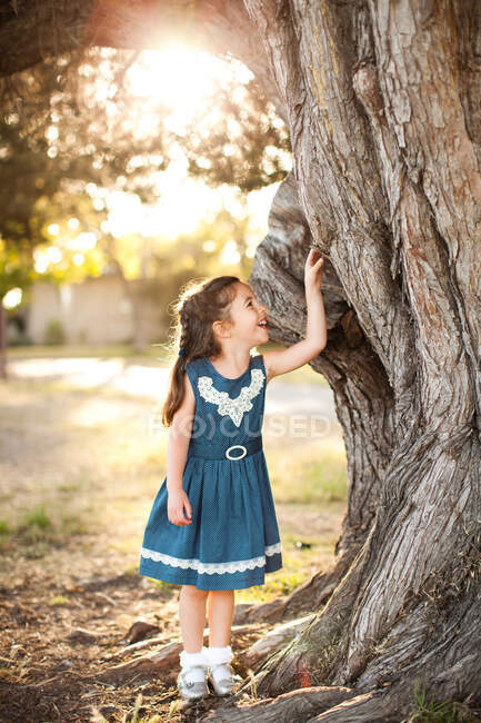 Retrato de menina tocando tronco de árvore — Fotografia de Stock