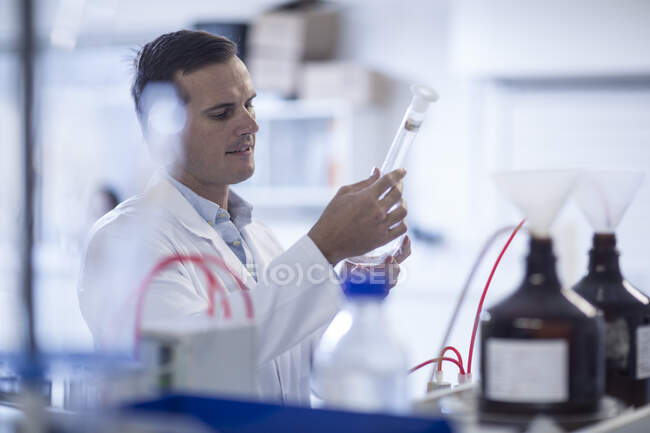 Кейптаун, Южная Африка, молодой мужчина смотрит на трубу в лаборатории — стоковое фото