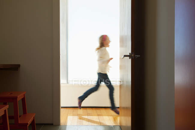 Chica corriendo por la puerta - foto de stock