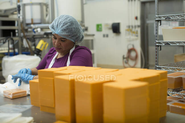 Frau verpackt veganen Käse in Lagerhalle — Stockfoto