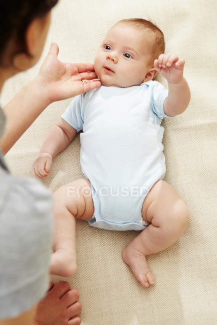Mère touchant la joue du bébé garçon — Photo de stock
