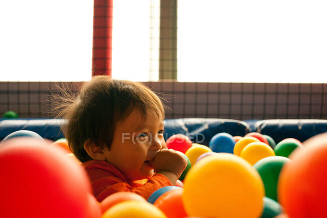 Garçon jouant dans la fosse à balles — Photo de stock
