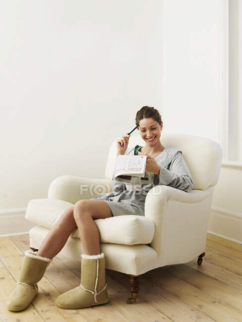Mulher fazendo quebra-cabeça no jornal — Fotografia de Stock