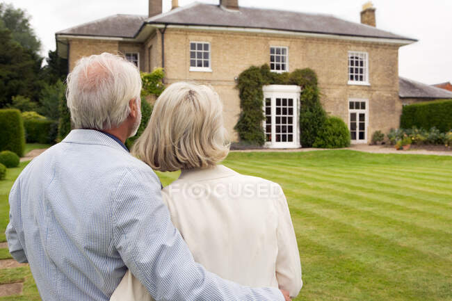 Couple sénior admirant maison — Photo de stock