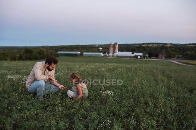 Padre e hija en la granja, cuidando de los cultivos - foto de stock