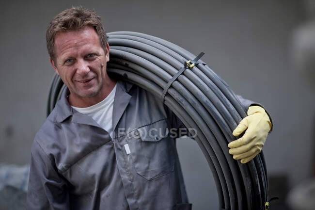Man carrying reel of cable — Stock Photo