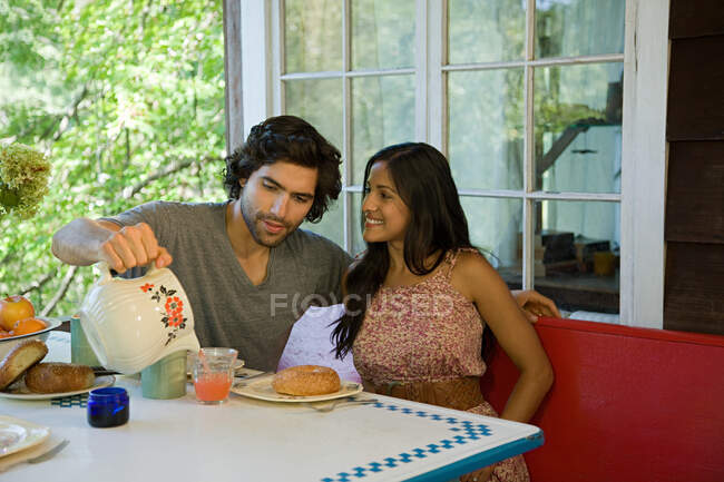 Man pouring juice for woman — Stock Photo