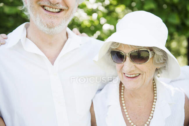 Retrato de mulher idosa usando óculos de sol e chapéu de sol branco — Fotografia de Stock