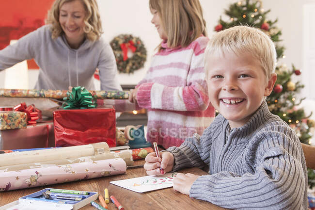 Mutter und Kinder wickeln Weihnachtsgeschenke ein — Stockfoto