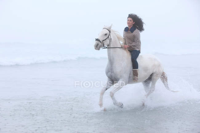 Mulher equitação cavalo na praia — Fotografia de Stock