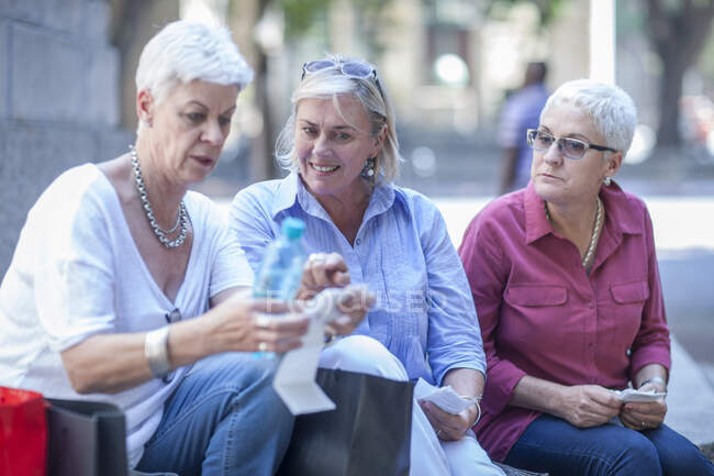 Elderly friends shopping together in city — Stock Photo