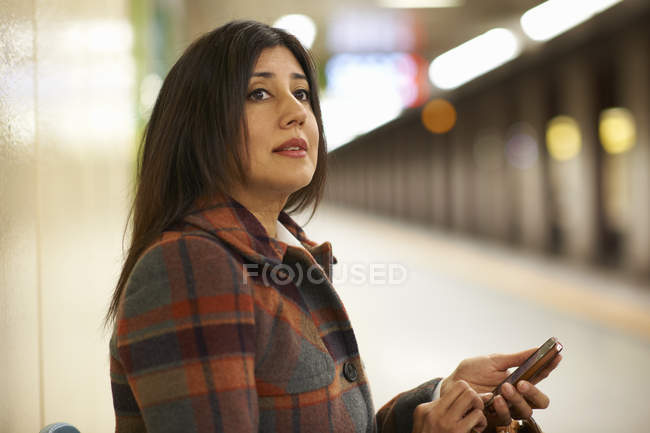Donna d'affari matura alla stazione della metropolitana della città utilizzando smartphone, Tokyo, Giappone — Foto stock