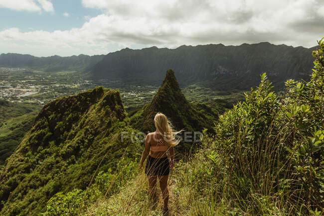 Rear view of woman on grass covered mountain, Oahu, Hawaii, USA — Stock Photo